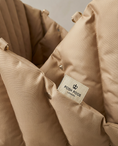 Load image into Gallery viewer, Close-up of a beige dog carseatt with a 'Posh Poos London' label.