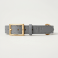 Load image into Gallery viewer, A gray leather puppy collar with a gold-tone buckle, shown in a clean studio shot against a light gray background.