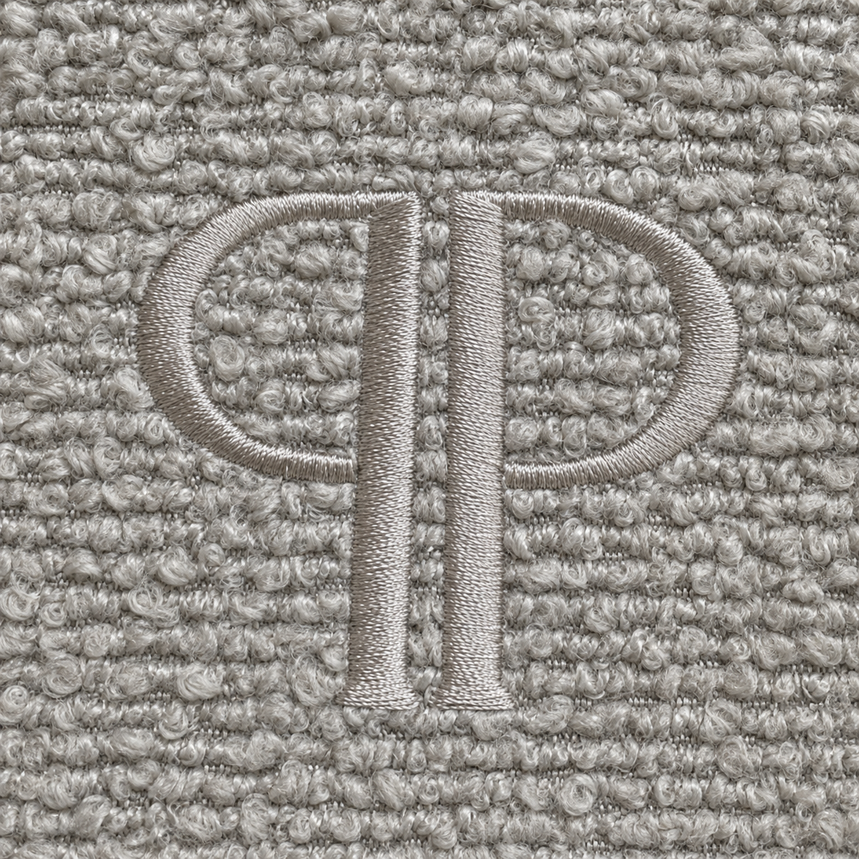 close up of the stone colour boucle fabric and embroidered pp monogram 