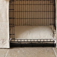 Load image into Gallery viewer, A black metal wire dog crate with a soft cream-colored boucle mattress inside with embroidered Posh Poos PP monogram.
