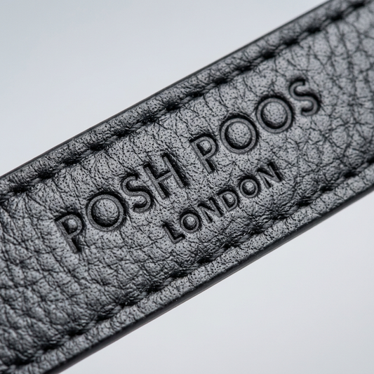 Close-up of a textured black leather dog lead with 'POSH POOS LONDON' branding.